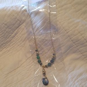 Long gold necklace with blue charms.